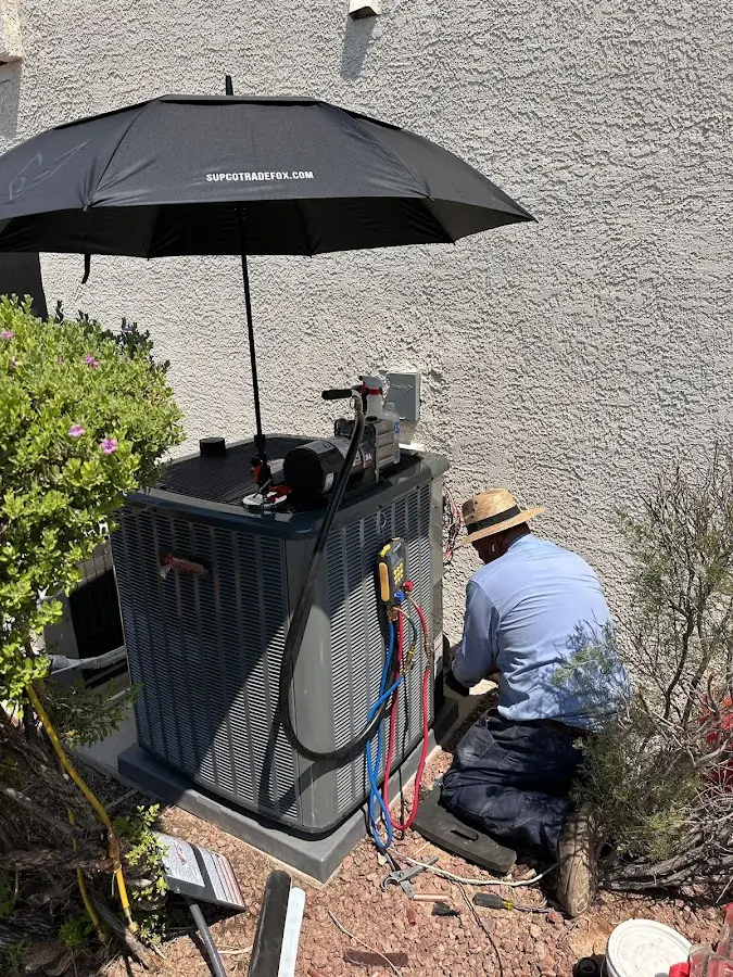 HVAC technician performing outdoor AC maintenance in Lumberton