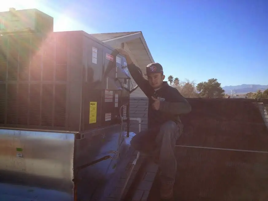 HVAC technician performing Boiler Repair on a rooftop unit in Lumberton